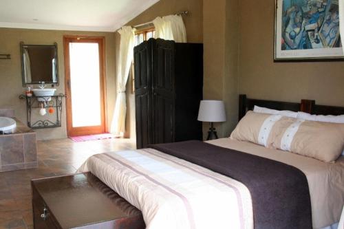 a bedroom with a large bed and a television at Rugare Sweet Dreams Holiday Cottage in Curryʼs Post