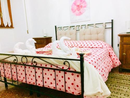 Schlafzimmer mit einem Bett mit roten Polka-Punkten in der Unterkunft Alloggio Turistico Isonzo - Bracciano (Roma) in Bracciano