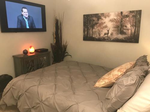 a bedroom with a bed and a flat screen tv at Home Sweet Condo in Calgary