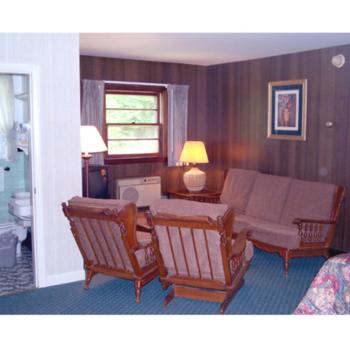 een woonkamer met een bank en stoelen bij Hill-Brook Motel in Bedford