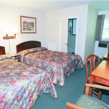 Habitación de hotel con 2 camas y escritorio en Hill-Brook Motel en Bedford
