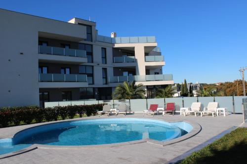 a swimming pool in front of a building at Apartmani Uwe in Banjole