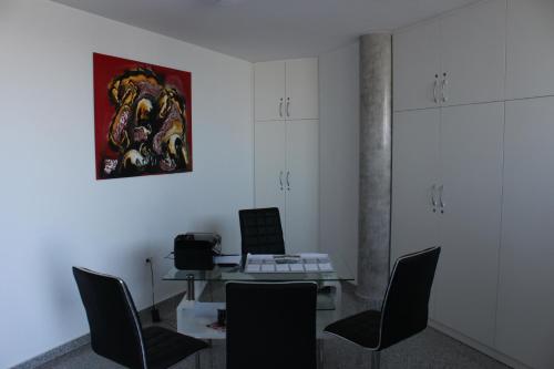ein Zimmer mit einem Tisch, Stühlen und einem Gemälde in der Unterkunft Apartmani Uwe in Banjole