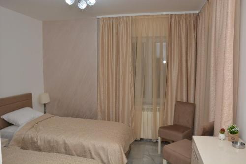 a hotel room with a bed and a chair at TREF in Prokuplje