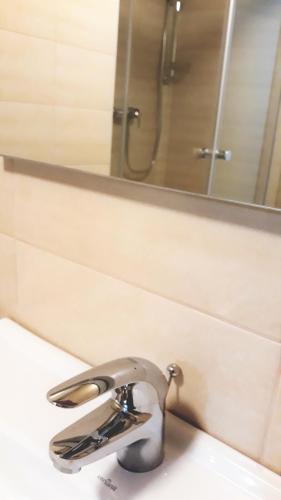 a bathroom sink with a faucet and a mirror at Apartments and Rooms Banić in Kranjska Gora