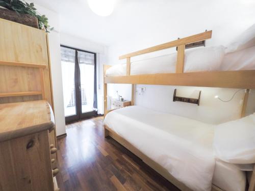 a bedroom with two bunk beds and a desk at L'Atelier du Temps - PanoramAlps Apartment in Courmayeur