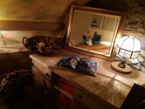 a mirror and a lamp on a dresser in a room at Hotel Ottoz Meublé in Courmayeur