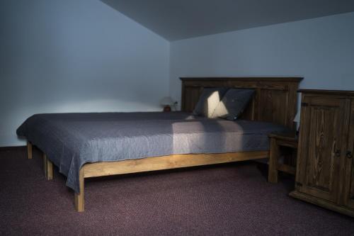 1 dormitorio con cama de madera y tocador de madera en Apartmány Biela Púť - Jasná, en Demänovská Dolina