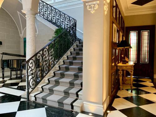a staircase in a house with a black and white checkered floor at Hotel Casa Palacio María Luisa in Jerez de la Frontera