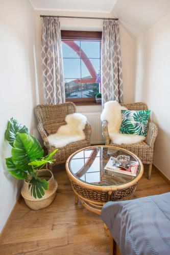 a living room with wicker chairs and a coffee table at Willa Ostoja Wellness in Świeradów-Zdrój