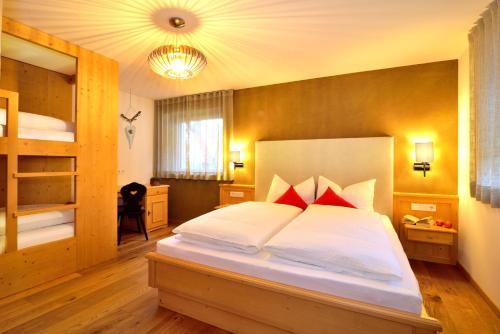 a bedroom with a large white bed with red pillows at Appartements Mayrhof in Bressanone