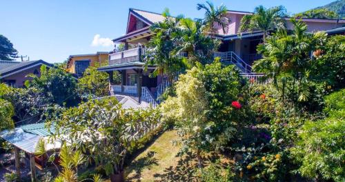 a house with trees in front of it at Romance Bungalows in Beau Vallon