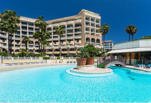 une piscine en face d'un grand bâtiment dans l'établissement Cannes design vue mer, à Cannes