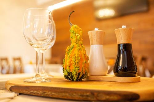 a wooden cutting board with a wine glass and a pineapple at Willa Ostoja Wellness in Świeradów-Zdrój