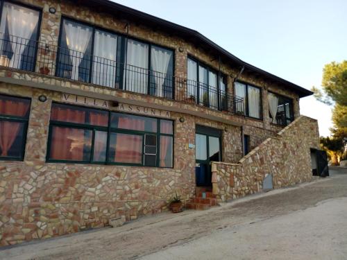 a stone building with windows and a balcony at Agriturismo Villa Assunta in Santa Caterina Villarmosa