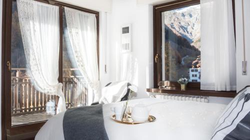 a bedroom with a bed and a large window at L'Atelier du Temps - PanoramAlps Apartment in Courmayeur