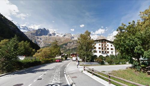 a street with a building on the side of a mountain at L'Atelier du Temps - PanoramAlps Apartment in Courmayeur