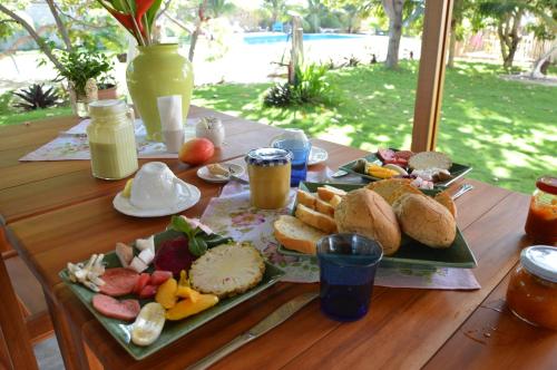 a wooden table with plates of food on it at Chill Mango in Paracuru