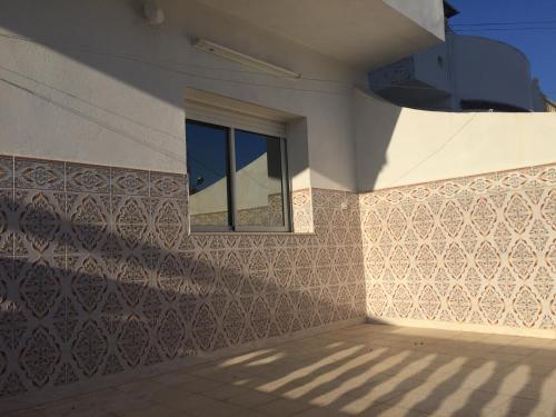 a window on the side of a building with a tile wall at Kélibia Paradise in Kelibia