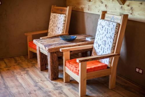 a wooden table with two chairs and a bowl on it at Siedlisko Wigry in Rosochaty Róg