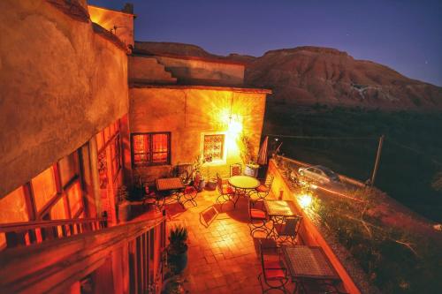 a balcony of a building with a table and chairs at Ayouze Auberge in Aït Benhaddou