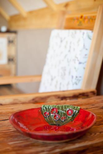 a red plate sitting on top of a wooden table at Siedlisko Wigry in Rosochaty Róg