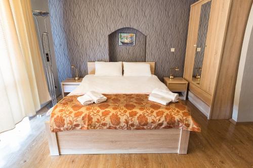 a bedroom with a bed with two towels on it at Alazani Valley Hotel in Tʼelavi