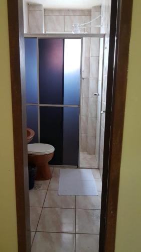 a small bathroom with a toilet and a shower at TRES TORRES POUSADA in Torres