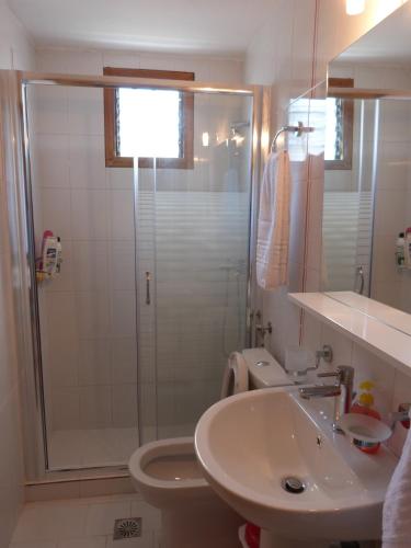 a bathroom with a shower and a sink and a toilet at Theathina in Kalamaki