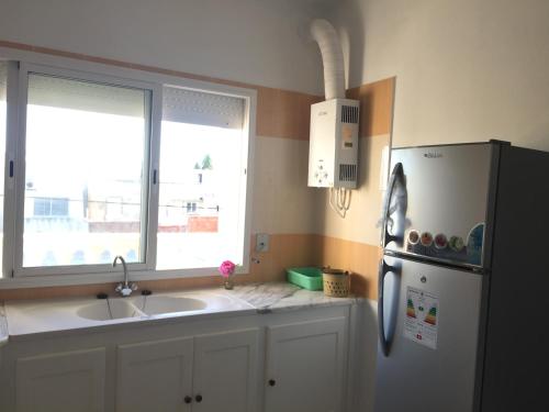 a kitchen with a refrigerator and a sink and a window at Kélibia Paradise in Kelibia