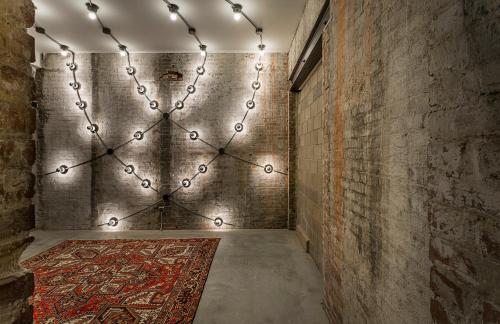 an empty corridor with a rug and lights on a wall at Crossroads Hotel in Kansas City