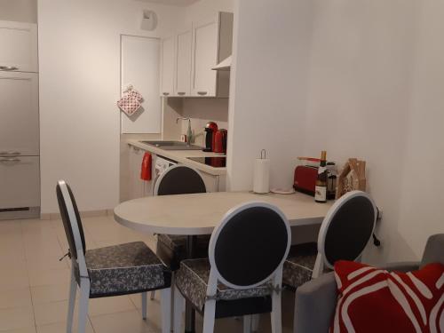 a kitchen with a table and chairs in a room at Le Carré des fleurs in Strasbourg