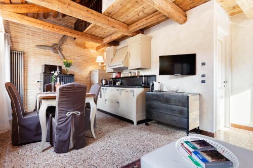 a kitchen and dining room with a table and a tv at Ca' Del Mariner apartment with Terrace in Venice