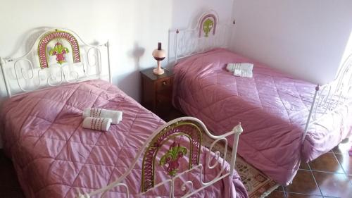 2 Betten in einem Zimmer mit rosa Bettwäsche in der Unterkunft Évora Romana Alojamentos T3 Cartuxa in Évora