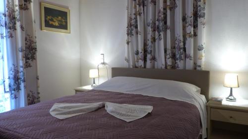 a bedroom with a bed and two lamps and a window at Theathina in Kalamaki Heraklion