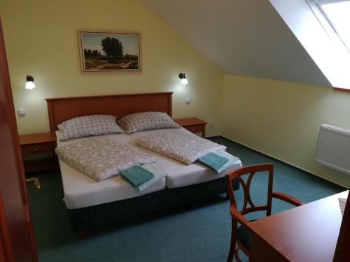 um quarto com uma cama com almofadas e uma mesa em Penzión Rodina em Levoča