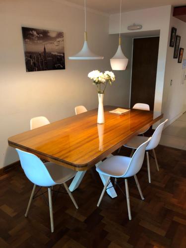 tavolo da pranzo con sedie e vaso con fiori di Mdz Apartments II a Mendoza