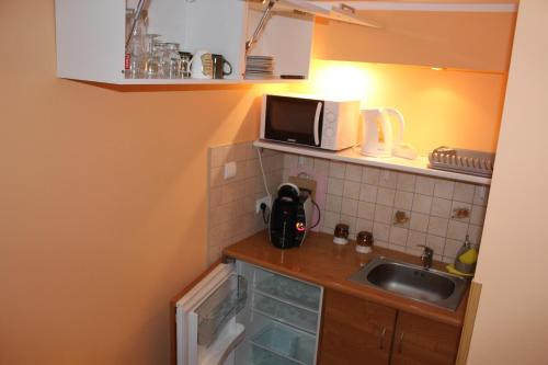 a small kitchen with a sink and a microwave at Pokój Kameralny- De Luxe z oddzielnym wejsciem in Karpacz