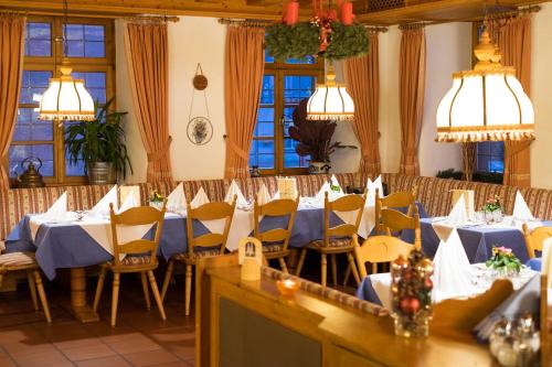 ein Esszimmer mit blauen Tischen, Stühlen und Fenstern in der Unterkunft Hotel zum Ochsen in Furtwangen