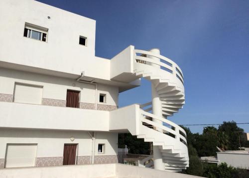 a building with a spiral staircase on the side of it at Kélibia Paradise in Kelibia