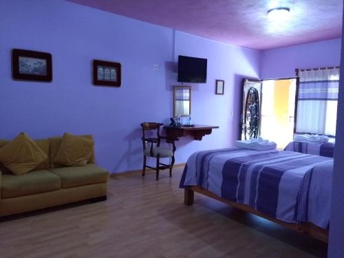 a bedroom with a bed and a couch and a desk at Hotel Zaragoza in Tepoztlán