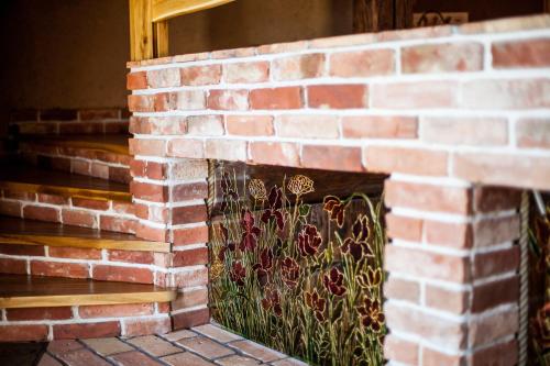 a brick fireplace with a stained glass window at Siedlisko Wigry in Rosochaty Róg