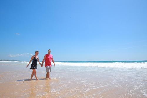 a man and a woman walking on the beach at Limecabanas-srilanka in Galle
