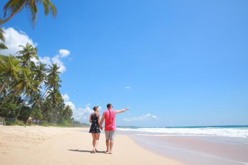 a man and a woman walking on the beach at Limecabanas-srilanka in Galle