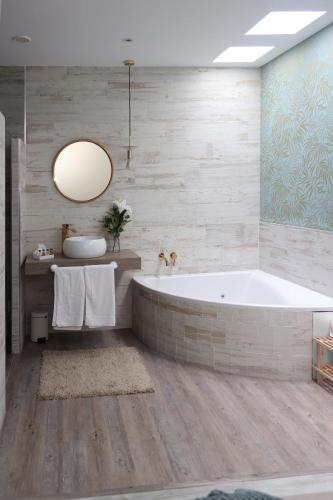 a bathroom with a tub and a sink at Apartamentos turísticos Desiree in Arévalo