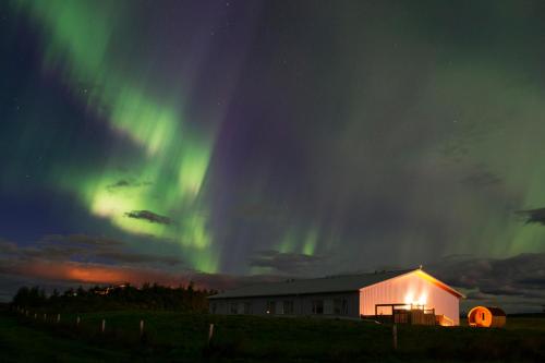an image of the aurora borealis over a building at Lambastadir Guesthouse in Selfoss