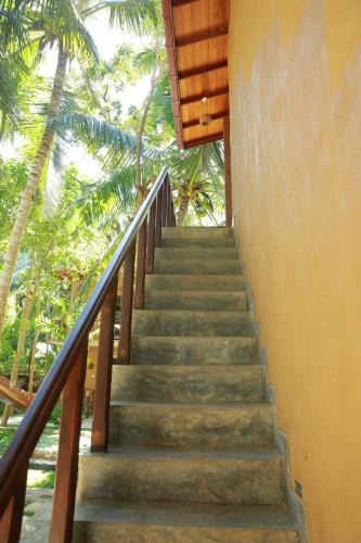 a staircase leading up to a building with palm trees at Limecabanas-srilanka in Galle