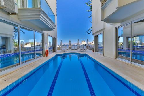 a swimming pool in a house with glass windows at Belinda Hotel in Kaş