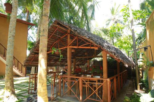a restaurant with a straw roof on top of a building at Limecabanas-srilanka in Galle