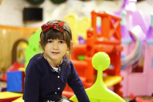 a young girl sitting on a toy car in a toy store at Hotel Toporów in Białka Tatrzanska